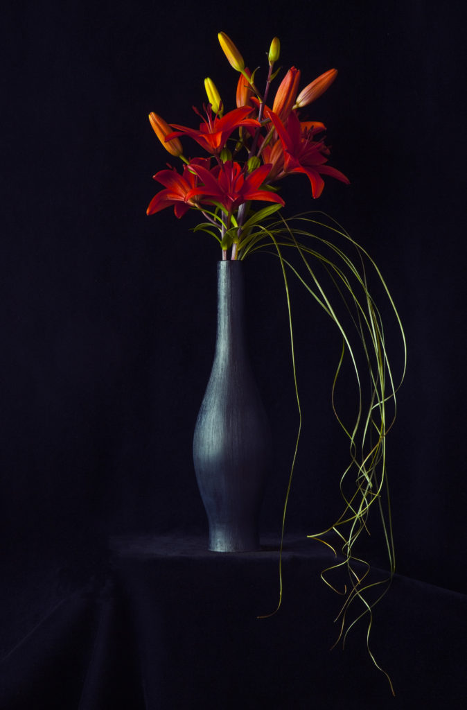 Red Asiatic Lilies in a Black Vase